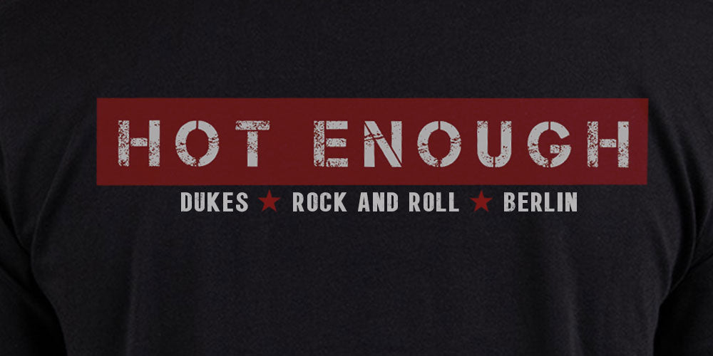 Vorderseite vom schwarzen DUKES Shirt der Berliner Hard Rock Band DUKES mit dem Album Schriftzug HOT ENOUGH und der Unterzeile DUKES, ROCK AND ROLL und BERLIN